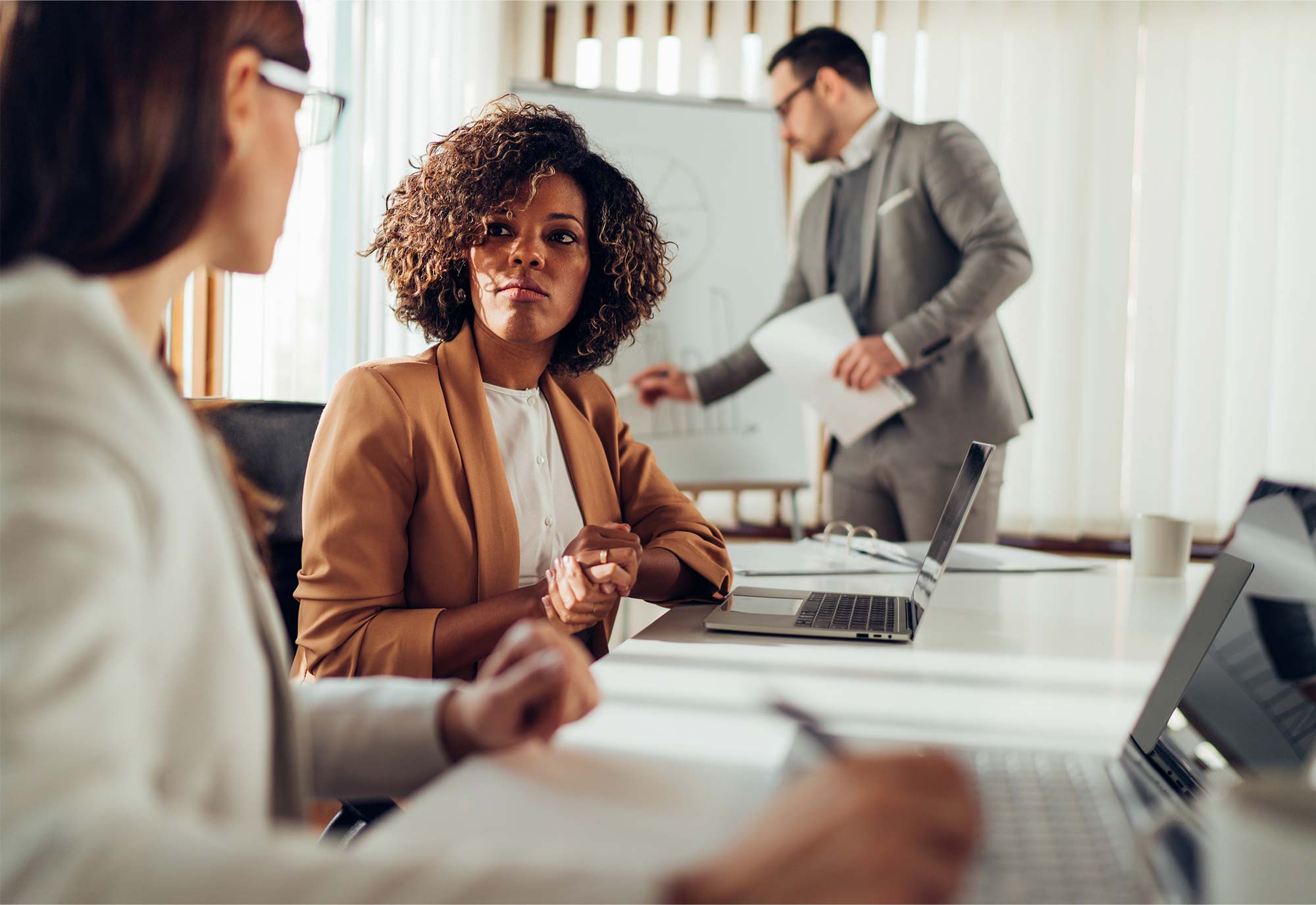 two women and man have a meeting in a business boardroom
